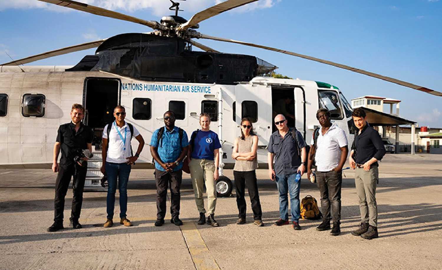 Tanya Birkbeck (in the dark blue shirt at centre) with World Food Program Haiti Country Director, WFP security and a CNN crew after a day of content collection in Jrmie, in the south of Haiti. The helicopter is a UN Humanitarian Air Service aircraft, which is a designated air service for humanitarian use, run by the WFP.